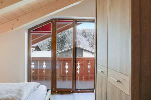 a bedroom with a large glass door leading to a balcony at Ferienwohnung Partnachklamm in Garmisch-Partenkirchen