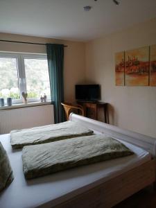 a bedroom with two beds and a window at Ferienwohnung Klaus in Treis-Karden