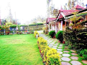 a stone path next to a house in a yard at Abu Residency in Kodaikānāl +11 photos