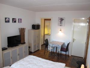 Pokój z łóżkiem, stołem i telewizorem w obiekcie Residenz Rosablanche, GENTIANES SIVI155 w mieście Siviez
