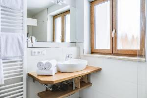 a white bathroom with a sink and a mirror at Ferienwohnung Geroldsee in Garmisch-Partenkirchen +17 photos