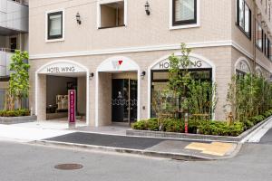 東京的住宿－Hotel Wing International Shimbashi Onarimon，城市街道上建筑物前面的商店