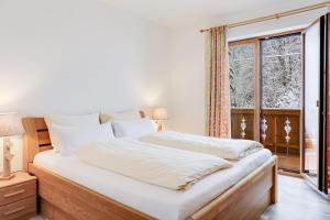 a bedroom with a large bed and a window at Ferienwohnung Geroldsee in Garmisch-Partenkirchen