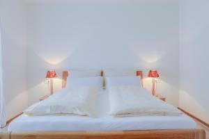 una camera con un letto bianco e 2 lampade di Ferienwohnung Schachen a Garmisch-Partenkirchen