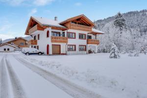 una casa con un'auto parcheggiata nella neve di Ferienwohnung Schachen a Garmisch-Partenkirchen