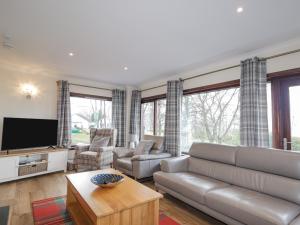 a living room with a couch and a tv at Fresh Fields in Dingwall