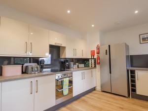 a kitchen with white cabinets and a stainless steel refrigerator at Fresh Fields in Dingwall
