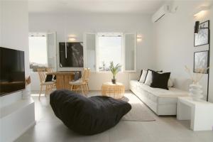 a white living room with a couch and a table at AELIA Tinos in Tinos