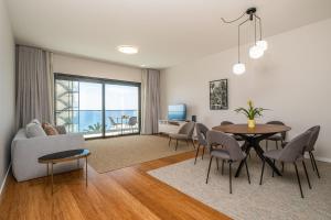 - un salon avec une table, des chaises et un canapé dans l'établissement Apartment with ocean view and parking, à Funchal