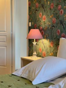 a bedroom with a bed with a lamp on a table at Ma Rosalie in Le Crotoy