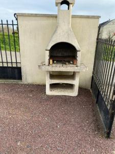 a brick oven sitting next to a fence at Gite aux grès des vents in Champeaux
