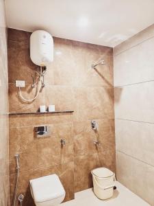 uma casa de banho com um WC e um chuveiro em Amahi Inn - Sector 48 em Gurgaon