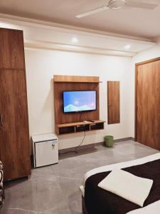 a bedroom with a flat screen tv on the wall at Amahi Inn - Sector 48 in Gurgaon +45 photos