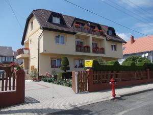 a house with a fence and a red fire hydrant at Judit Vendégház in Hévíz +34 photos