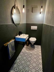 een badkamer met een wastafel, een toilet en een spiegel bij MoPa - Stylisch wohnen zwischen Alb und Legoland in Leipheim