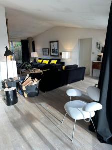 - un salon avec un canapé, des tables et des chaises dans l'établissement Villa K Maison archi avec piscine 15 mn PUY du FOU, à Cholet