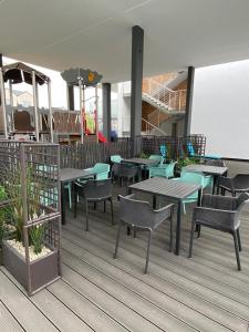a restaurant with tables and chairs on a deck at Kapitańska 16C31 in Grzybowo