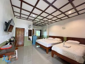 una camera d'albergo con due letti e una tv di Baan Khue Wieng Resort a Mae Sariang