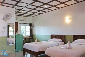 una camera con due letti e uno specchio di Baan Khue Wieng Resort a Mae Sariang