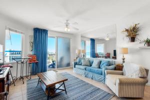 a living room with a blue couch and a table at Destin West Gulfside #608 in Fort Walton Beach