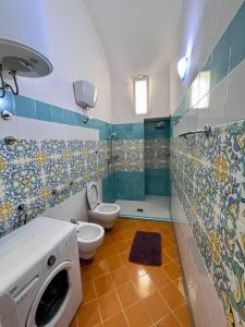 a bathroom with a toilet and a washing machine at Sant Angelo Centro in Ischia