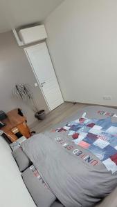 a bedroom with a bed with a quilt on it at Maison duplex de ville avec terrasse et clim in Foucherans