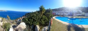 an aerial view of a swimming pool next to the ocean at Casa Altos 76 in La Herradura