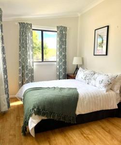 um quarto com uma cama grande e uma janela em Wattle Cottage em Mandurama