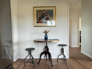 a table with two stools and a vase on it at Wattle Cottage in Mandurama