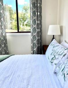 uma cama num quarto com uma janela e uma cama sidx sidx em Wattle Cottage em Mandurama