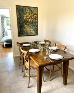 uma sala de jantar com uma mesa de madeira e cadeiras em Wattle Cottage em Mandurama