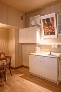 a kitchen with white cabinets and a sink and a table at St.Jacobs's apartments Old Town Riga in Rīga