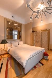 um quarto com uma grande cama branca e um lustre em St.Jacobs's apartments Old Town Riga em Riga