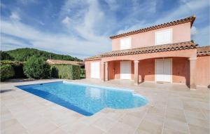 a villa with a swimming pool in front of a house at Cozy Home In Les Arcs With Kitchen in Les Arcs sur Argens