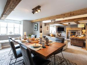 a dining room and living room with a table and chairs at Longlands Farm Cottage in Grange Over Sands