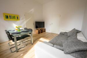 a living room with a table and a bed and a television at Kleine, ruhig gelegene Ferienwohnung in Plauen in Plauen