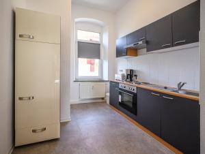 a kitchen with black and white appliances and a window at Kleine, ruhig gelegene Ferienwohnung in Plauen in Plauen