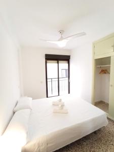 ベニドルムにあるApartamento Playa Benidormの白いベッドルーム(大型ベッド1台、窓付)