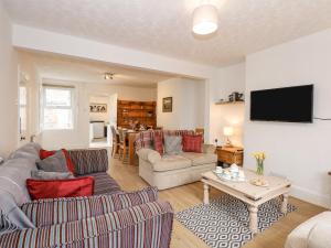 a living room with two couches and a table at Fieldview Cottage in Great Massingham