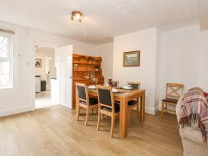 a dining room with a wooden table and chairs at Fieldview Cottage in Great Massingham