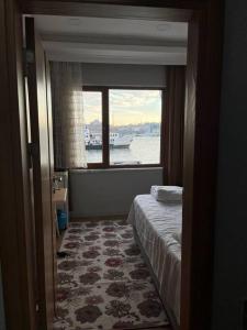 伊斯坦堡的住宿－A Beachfront, Peninsula View Apartment in Karaköy，卧室设有窗户,卧室内设有一张床