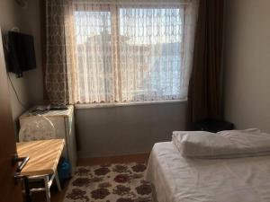 伊斯坦堡的住宿－A Beachfront, Peninsula View Apartment in Karaköy，一间卧室配有一张床、一张桌子和一个窗户。