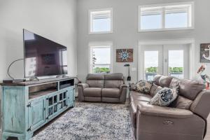 a living room with a couch and a flat screen tv at Pelican at Sound Side in Fort Walton Beach
