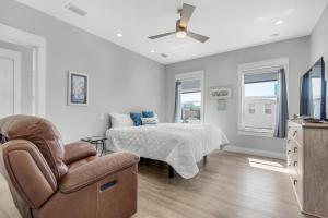 a bedroom with a bed and a chair at Pelican at Sound Side in Fort Walton Beach +69 photos