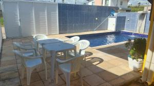a table and chairs on a patio with a pool at Casa com picina in São José da Coroa Grande