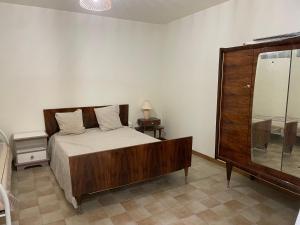1 dormitorio con 1 cama grande y espejo en T3 rénové esprit vintage, au coeur du Verdon en Montagnac
