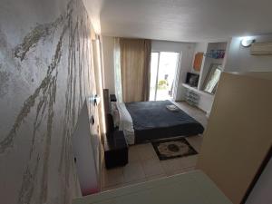 a small bedroom with a bed and a window at Azalea Garden Apartment With Mountain View in Kremasti