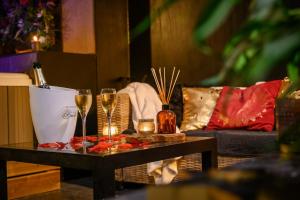 a table with two glasses of wine and a couch at Spa Maroilles in Maroilles