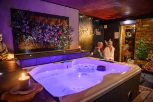 a bathroom with a jacuzzi tub with a candle at Spa Maroilles in Maroilles