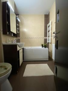 een badkamer met een bad, een wastafel en een toilet bij Apartament EXCLUSIVE Târgu Ocna in Tîrgu Ocna